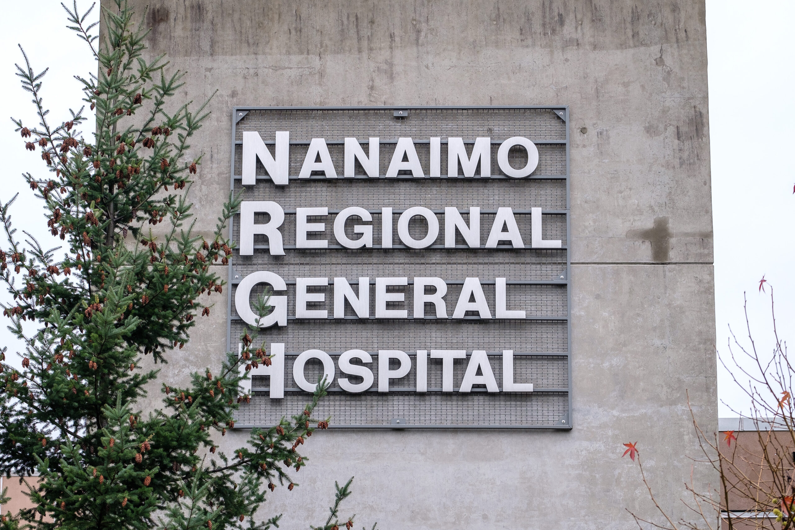 A metal sign placed on a concrete wall reads 'Nanaimo Regional General Hospital'