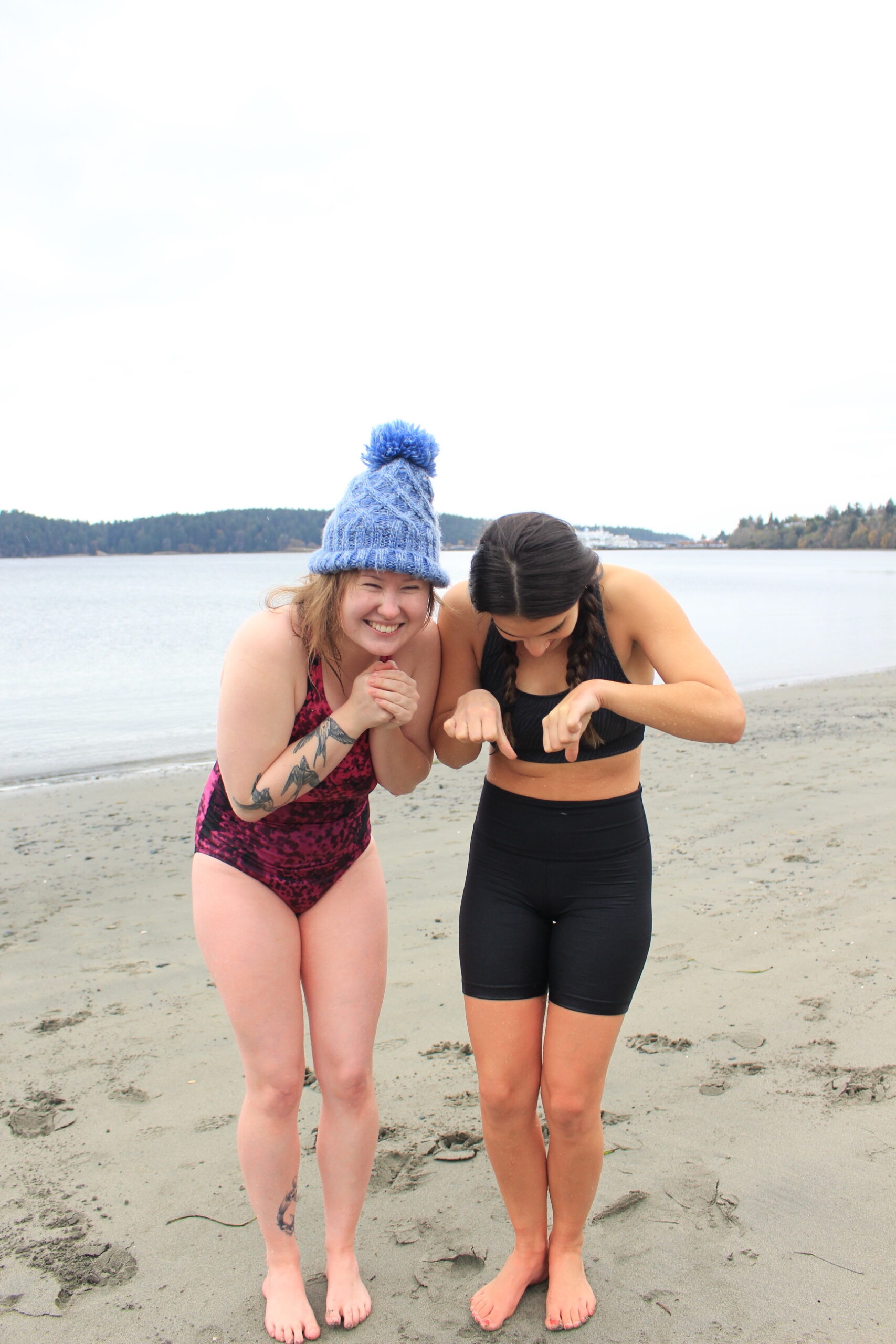Bella Hoodle and Megan Zolorycki stand shivering after going neck-deep into the ocean at Departure Bay, in Nanaimo.