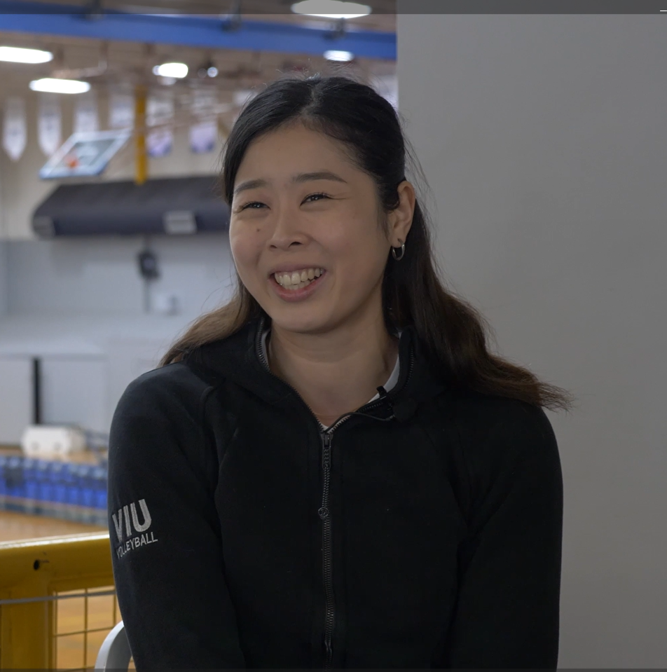 Mika Yamada sits with the VIU gym behind her
